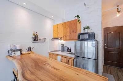 a kitchen with a wooden counter top and a refrigerator at Yūgen 幽玄 Makati Home - Malls, Little Tokyo, Pool in Manila