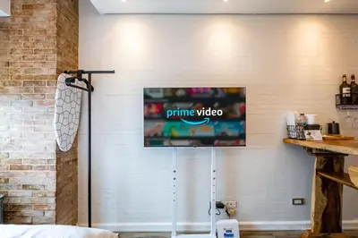 a television hanging on a brick wall at Yūgen 幽玄 Makati Home - Malls, Little Tokyo, Pool in Manila