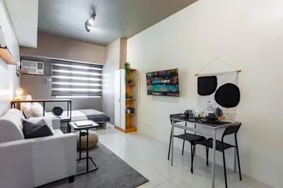 a living room with a couch and a table at Makati Condo Near NAIA & Greenbelt - Free Parking! in Manila