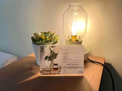 a sign on a table with a lamp and a potted plant at Makati Condo Near NAIA & Greenbelt - Free Parking! in Manila