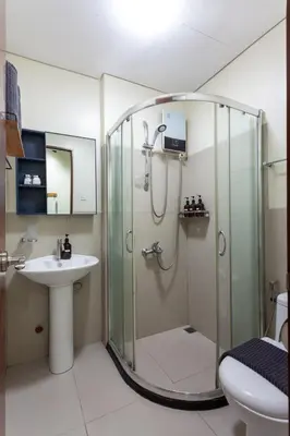 a bathroom with a shower and a sink at Makati Condo Near NAIA & Greenbelt - Free Parking! in Manila
