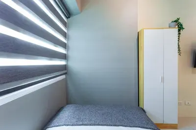 a bedroom with a bed and a window at Makati Condo Near NAIA & Greenbelt - Free Parking! in Manila