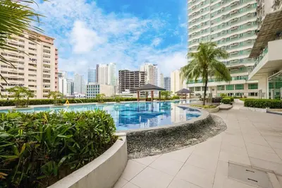 a large swimming pool in a city with tall buildings at Makati Condo Near NAIA & Greenbelt - Free Parking! in Manila