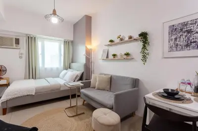 a living room with a bed and a couch and a chair at Makati Condo Near Airport & Greenbelt in Manila