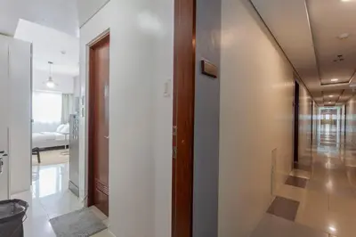 a hallway with a door leading to a bedroom at Makati Condo Near Airport & Greenbelt in Manila