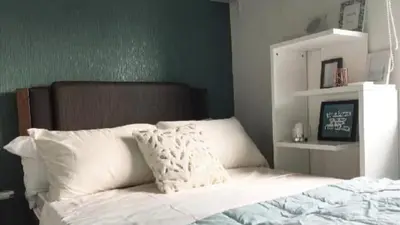 a bed with white sheets and pillows in a bedroom at Portovita Towers in Manila