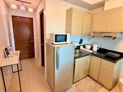 a kitchen with a microwave on top of a refrigerator at New Beacon Makati Condo Near Airport with Pool Access in Manila