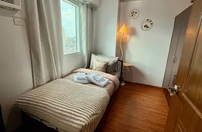 a small room with a bed and a window at New Beacon Makati Condo Near Airport with Pool Access in Manila
