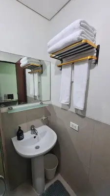 a bathroom with a sink and a mirror and towels at New Beacon Makati Condo Near Airport with Pool Access in Manila