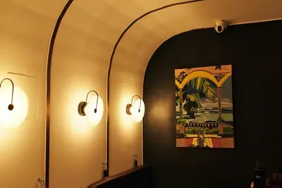 a bathroom with two lights and a mirror at The Kin House - Poblacion Botique Hotel in Manila