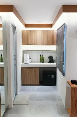 a kitchen with wooden cabinets and a black dishwasher at The Kin House - Poblacion Botique Hotel in Manila