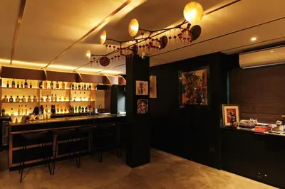 a bar with a counter and chairs in a room at The Kin House - Hotel in the Heart of Poblacion in Manila