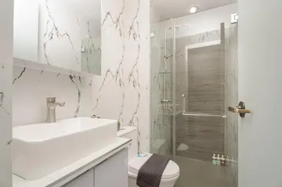 a bathroom with a shower and a toilet and a sink at NEW! Modern Condo in Greenbelt Makati with Pool & Gym in Manila