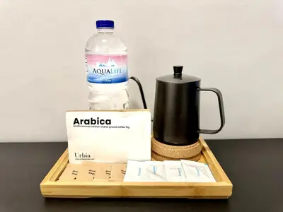 a bottle of water sitting next to a coffee maker at Charming Studio in Greenbelt Makati - Near Malls! in Manila