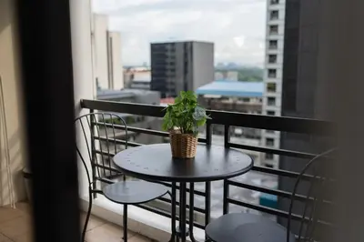 a potted plant sitting on a table on a balcony at Studio in Greenbelt Makati with Fiber WiFi & Free Pool Access in Manila