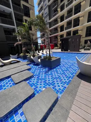 a pool with chairs and trees in a building at Gentry Manor Pet Friendly Near MOA&NAIA Okada Complex 8T in Manila