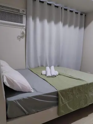 a bedroom with a bed with two towels on it at Gentry Manor Pet Friendly Near MOA&NAIA Okada Complex 8T in Manila