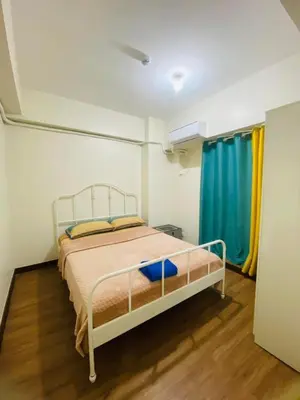 a bedroom with a bed and a blue curtain at Urban Resort District in Manila