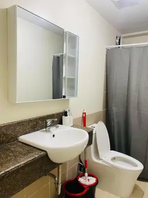 a bathroom with a sink and a toilet and a mirror at Urban Resort District in Manila