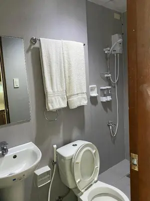 a bathroom with a toilet and a sink and towels at Ohana Buenbyahe Studio Rooms with balcony in Mandaluyong, Edsa Shaw Mrt and Megamall in Manila