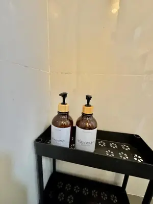 two bottles of soap sitting on a black shelf at Sunshine 100 Cozy Mandaluyong Studio Near BGC in Manila