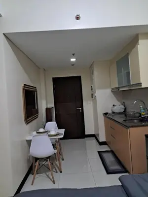 a kitchen with a table and chairs in a room at 101 Newport Boulevard-Hyuna Place, Across NAIA T3 in Manila