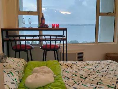 a living room with a table and a couch and a window at Chic Haven in Manila