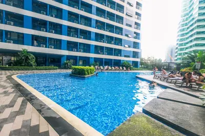 a large swimming pool in front of a building at Alice in Wonderland Enchanting Makati Retreat 300 Mbps in Manila