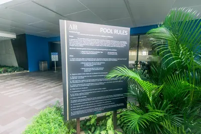 a sign in front of a building with plants at Alice in Wonderland Enchanting Makati Retreat 300 Mbps in Manila