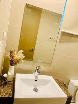 a bathroom with a sink and a mirror at Across NAIA terminal 3 in Manila