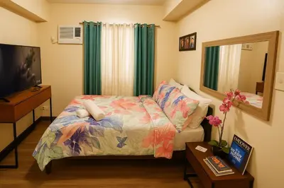 a small bedroom with a bed and a mirror at La Verti Residences Unit 1420 I Skyline Views & Luxe Stay Near MOA in Manila