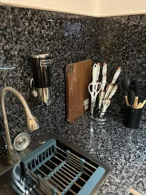 a kitchen counter with a dish drying rack and utensils at Modern Studio near MOA, Airport & Heart of Pasay in Manila