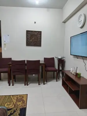 a living room with a table and chairs and a flat screen tv at Cozy Jen 150newport Boulevard condotel in Manila