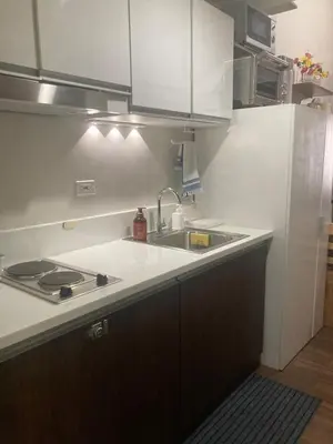 a kitchen with a sink and a stove in it at Rustic condo in Makati CBD in Manila