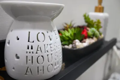a white vase sitting on a shelf with a bowl of plants at CASA Salcedo - Field Residences in Manila