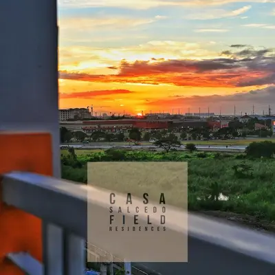 a sign on a balcony with a sunset in the background at CASA Salcedo - Field Residences in Manila