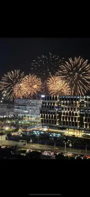a fireworks display over a large building with cars at Affordable Condo staycation near MOA ,NAIA & Airport 4 GUESTS WIFI,NETFLIX,POOL in Manila
