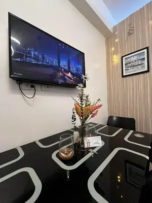 a living room with a table and a flat screen tv at Affordable Condo staycation near MOA ,NAIA & Airport 4 GUESTS WIFI,NETFLIX,POOL in Manila