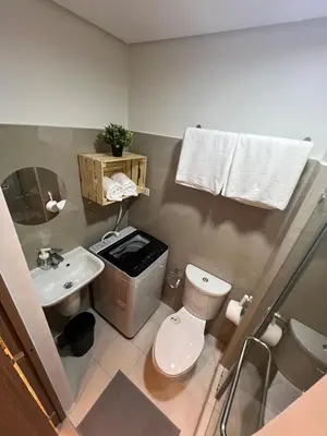 a small bathroom with a toilet and a sink at Snuggle Suites in Manila