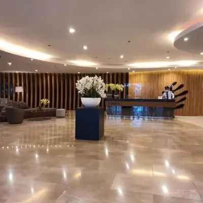 a lobby with a vase of flowers in the middle at Snuggle Suites in Manila