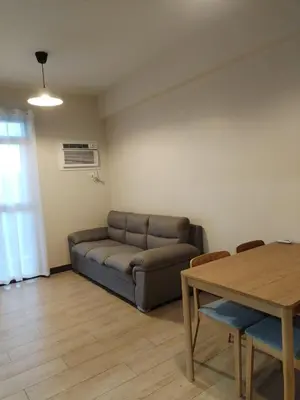 a living room with a couch and a table at Near MOA 3 pax unit in Gentry Manor in Manila