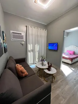 a living room with a couch and a table at Moa Gentry Manor WIFI TV Balcony with view Beside Okada in Manila