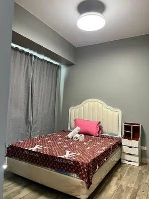 a bedroom with a bed with a stuffed animal on it at Moa Gentry Manor WIFI TV Balcony with view Beside Okada in Manila