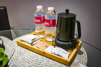 a tray with two bottles of water on a table at Snug Stay in Gramercy Makati with City Skyline View! in Manila