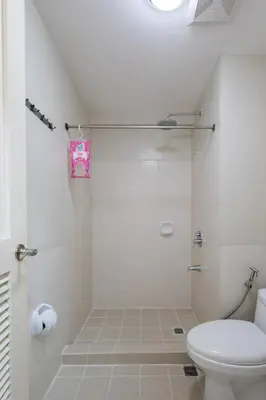 a white bathroom with a toilet and a shower at NEW 2BR Family Home with FREE Parking & Fiber Wi-Fi in Manila