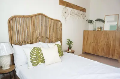 a bedroom with a large white bed with pillows at Modern Tropical Home In The Heart of Quezon City in Manila