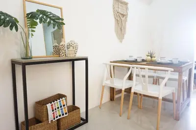 a dining room with a table and chairs and a mirror at Modern Tropical Home In The Heart of Quezon City in Manila