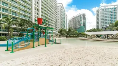 a playground in the middle of a beach with buildings at The Dream Den Staycation in Manila