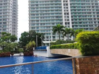 a large pool of blue water with tall buildings at The Dream Den Staycation in Manila