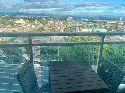 a balcony with a table and chairs and a view of a city at The Dream Den Staycation in Manila